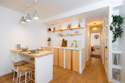 - une cuisine aux murs blancs avec un comptoir et un évier dans l'établissement Appartement au cœur de La Rochelle avec terrasse, à La Rochelle