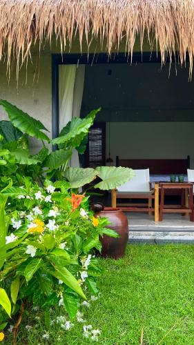 a house with a grass roof and some plants at Private 4 bedrooom Nongnia Beach Villas in Tân Thành (1)