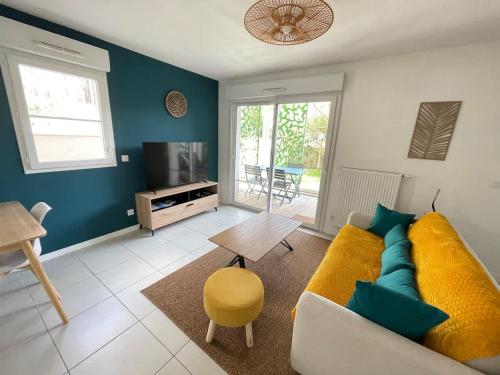 a living room with a couch and a table at Joli appartement rénové La Rochelle in La Rochelle