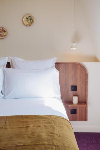 a bedroom with a bed with white sheets and a night stand at LALA Hôtel in Paris