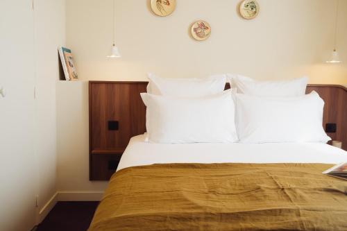 a bedroom with a large bed with white pillows at LALA Hôtel in Paris