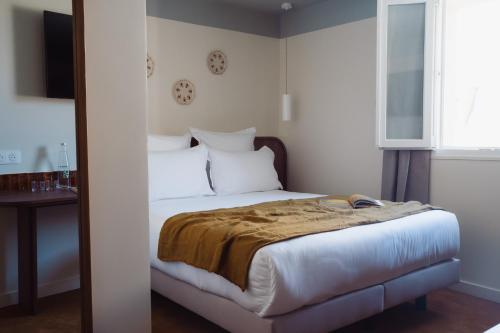 a bedroom with a bed and a table and a window at LALA Hôtel in Paris