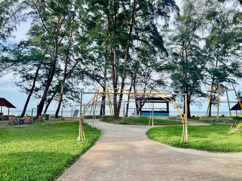 un chemin dans un parc avec une aire de jeux dans l'établissement Desaru beach stay Tiara residences, à Bandar Penawar