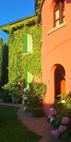 a ivycovered building with green doors and windows at Hotel La Selce in Monselice