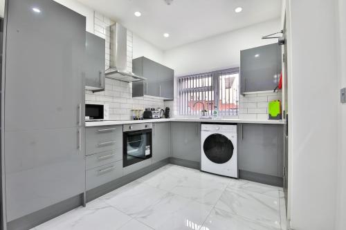 カーディフにあるModern 2 Bedroom House in Central Cardiffの白い大型キッチン(洗濯機、乾燥機付)