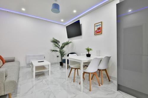カーディフにあるModern 2 Bedroom House in Central Cardiffの白いテーブルと椅子のある白いダイニングルーム