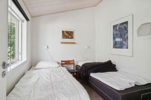 une chambre avec deux lits et une fenêtre dans l'établissement Lovely Cottage Close To Beach And Nature, à Yderby