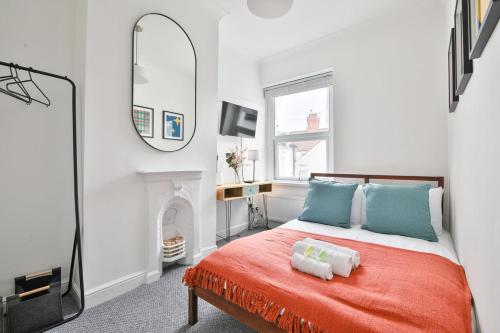 a bedroom with a bed with a mirror and a fireplace at Stunning Cardiff Bay House in Cardiff