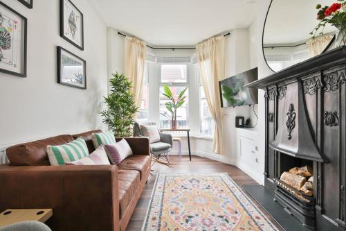 a living room with a couch and a fireplace at Stunning Cardiff Bay House in Cardiff
