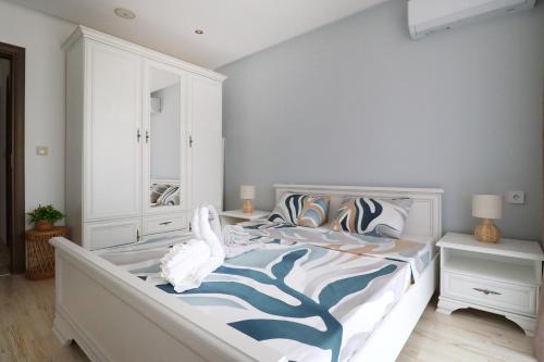 a bedroom with a bed with a blue and white comforter at Stylish Paradiso Apartment 206 in Nesebar