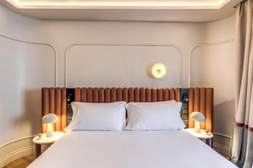 a bedroom with a large bed with two lamps at Dimora Coppelle in Rome