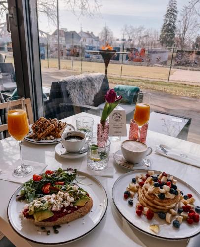 a table with plates of food and drinks on it at Atelier Lanna in České Budějovice
