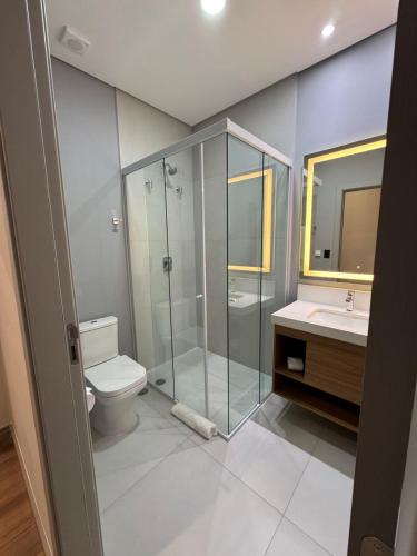 a bathroom with a shower and a toilet and a sink at Pousada Big Bear in Campos do Jordão