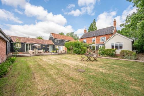 ein Hinterhof eines Hauses mit einem Garten sidx sidx in der Unterkunft Thyme Shepherds Hut Boundary Farm, Framlingham in Woodbridge