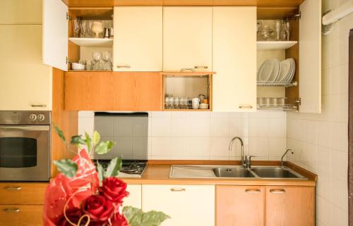 a kitchen with white cabinets and a sink at La Casa Di Rosa in Matera