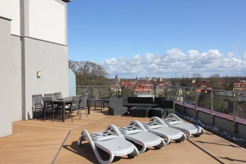 a balcony with chairs and a table on a building at Apartamenty Rondo in Świnoujście