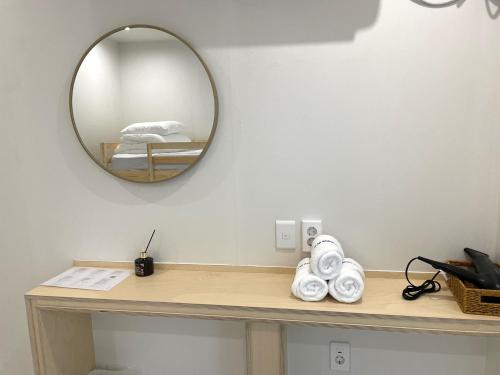 a mirror on the wall above a table with towels at Londonker in Busan