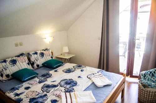 a bedroom with a bed with blue and white sheets and a window at Villa Lakeview Paradise in Peštani