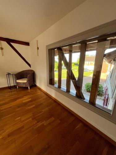 a room with a large window and a wooden floor at La Roselière du Der in Giffaumont