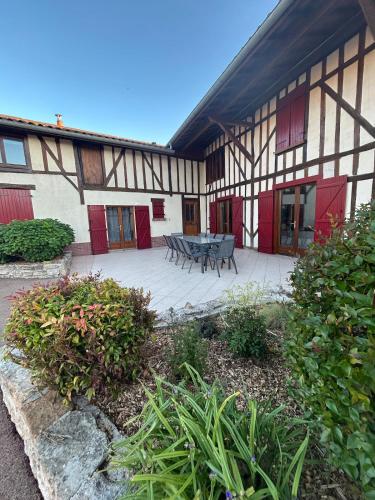 a building with a patio with a table and benches at La Roselière du Der in Giffaumont