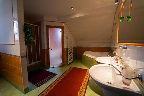 a bathroom with two sinks and a bath tub at Penzion HACIENDA in Liptovská Osada
