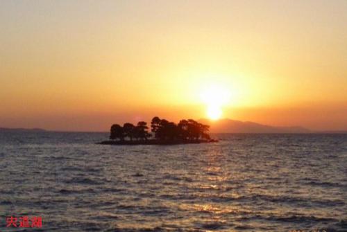 a small island in the ocean at sunset at 福のや in Unnan