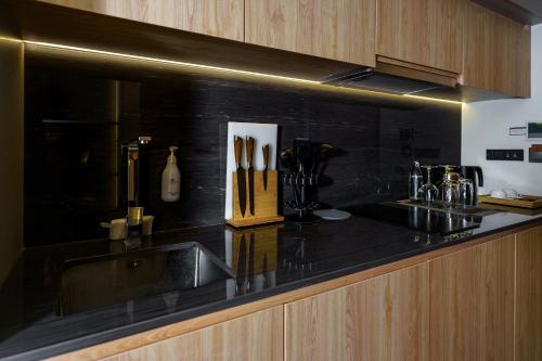 a kitchen with a black counter top with a sink at Amazing La Green 10 min walk to Layan Beach in Layan Beach