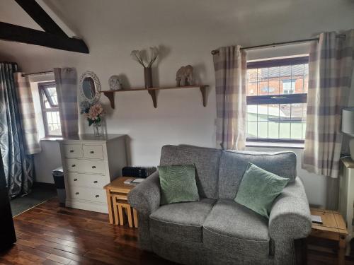a living room with a couch and a window at Joiners Arms - Studio Apartments in Market Drayton