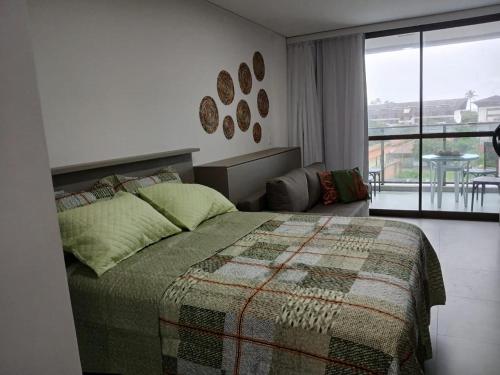 a bedroom with a bed and a view of a balcony at FLAT BEACH CLASS SUMMEr PORTO DE GALINHAS in Porto De Galinhas