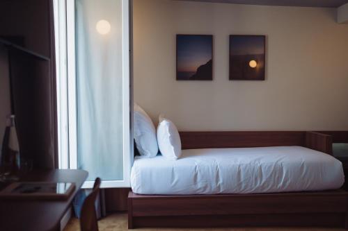 a bedroom with a bed and a large window at LALA Hôtel in Paris