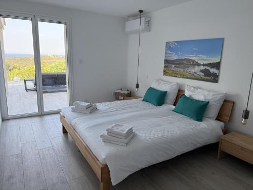 une chambre blanche avec un grand lit avec des oreillers verts dans l'établissement Casa Tre Fari, à Bocca del Oro