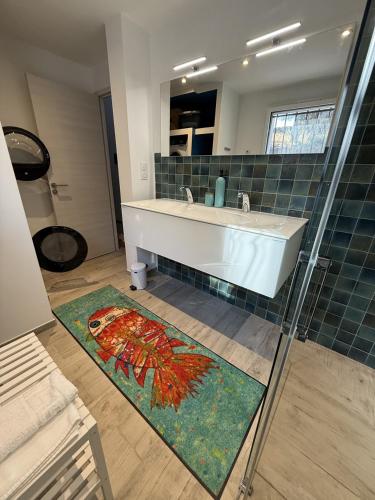 La salle de bains est pourvue d'une baignoire, d'un lavabo et d'un tapis. dans l'établissement Casa Tre Fari, à Bocca del Oro