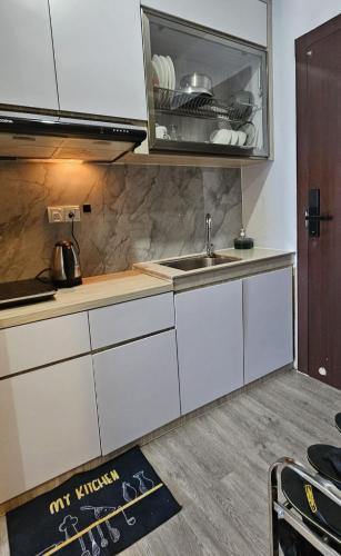 a kitchen with white cabinets and a sink at Risa Formosa, studio 25-10 in Jodoh