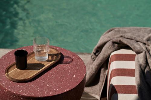 a wooden tray with a glass on top of a table at NAUMA PAROS Design Boutique Hotel in Naousa