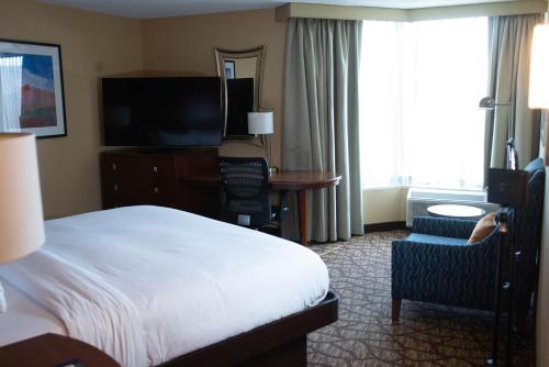 a hotel room with a bed and a desk and a television at DoubleTree by Hilton Hotel Oak Ridge - Knoxville in Oak Ridge
