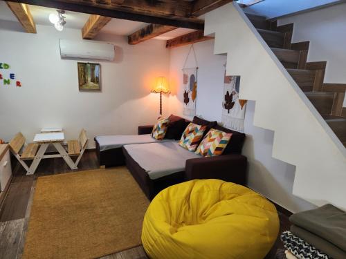 a living room with a couch and a yellow ottoman at Ház a szígeten in Fonyód