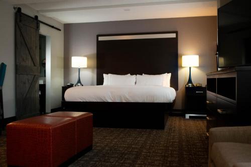 a hotel room with a large bed and a couch at DoubleTree by Hilton Hotel Oak Ridge - Knoxville in Oak Ridge