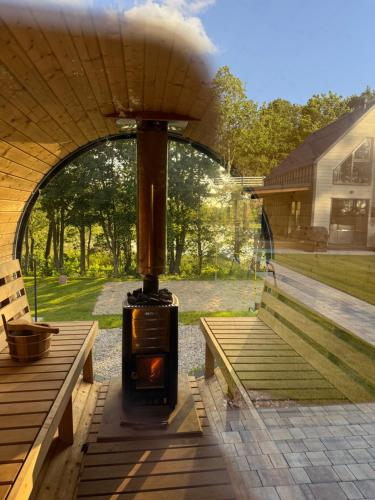 a wood fired stove in a house with a patio at Cicha Woda - domki in Nowe Bagienice
