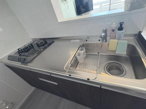 a kitchen sink with a dish drying rack in it at Crest Blue 403-オーシャンフロント! 新築マンション! in Kin
