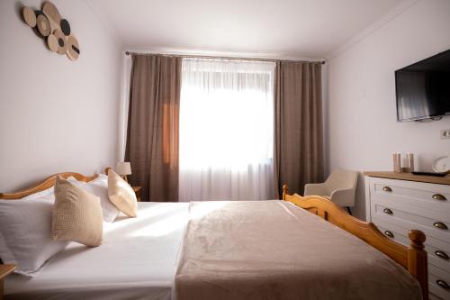 a bedroom with a large bed with a window at Aly&Emy 2 in Caransebeş