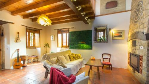 a living room with a couch and a fireplace at Casa Raiz Guest House & Retiro in Ferreira do Zêzere
