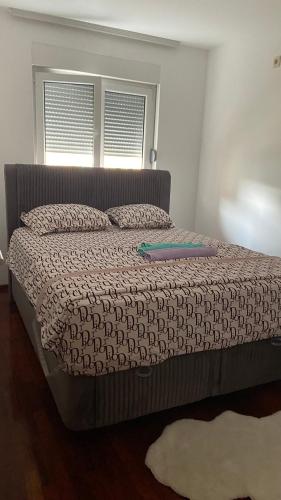 a bed with a comforter and a book on it at One bedroom apartment Podgorica in Podgorica