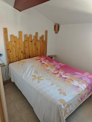 une chambre avec un lit avec une tête de lit en bois dans l'établissement L'anse duRhône, à Port-Saint-Louis-du-Rhône