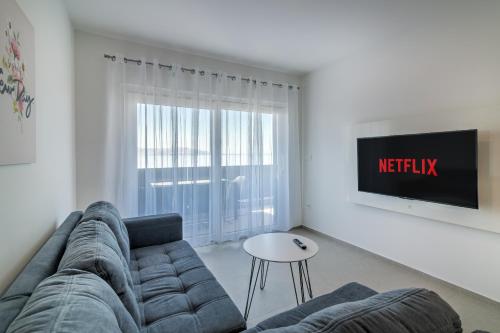 a living room with a couch and a tv at Apartmani Olimp2 in Sveti Juraj