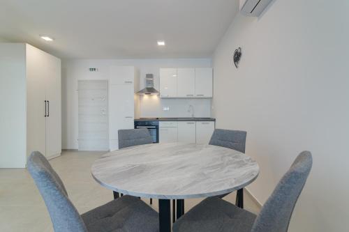 a dining room with a table and chairs at Apartmani Olimp2 in Sveti Juraj