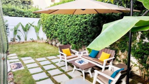a patio with two chairs and an umbrella at Dar Houta Hammamet Mrezga in Nabeul