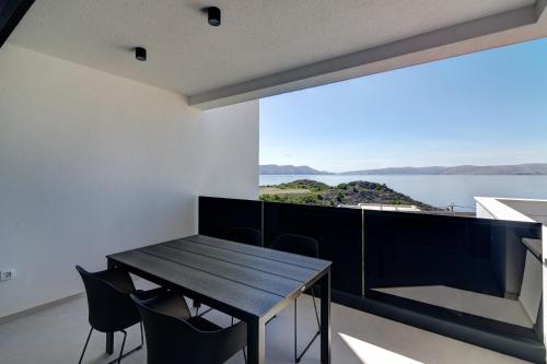 a dining room with a table and chairs and a large window at Apartmani Olimp2 in Sveti Juraj