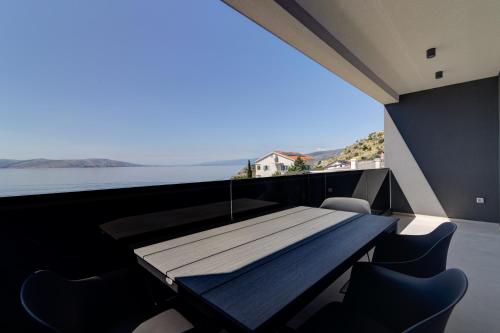 a table in a room with a view of the water at Apartmani Olimp2 in Sveti Juraj