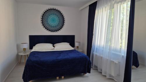 a bedroom with a blue bed and a window at Apartamenty Bujowy in Ustroń