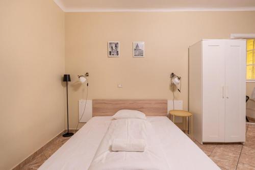a bedroom with a large white bed and a lamp at EcoStay Apartment by the Basilica in Budapest